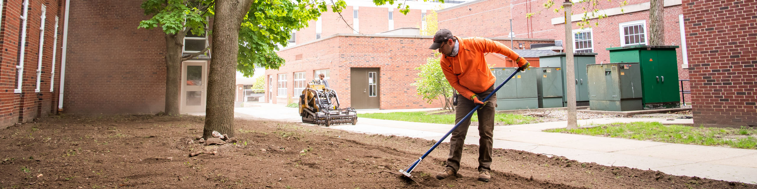 Grounds workers maintain the grass around the quad.
