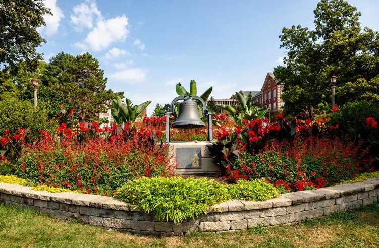 Old Main Bell in summer surrounded by flowers