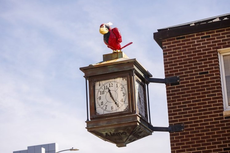 Reggie Redbird clock mounted on the side of the campus bookstore
