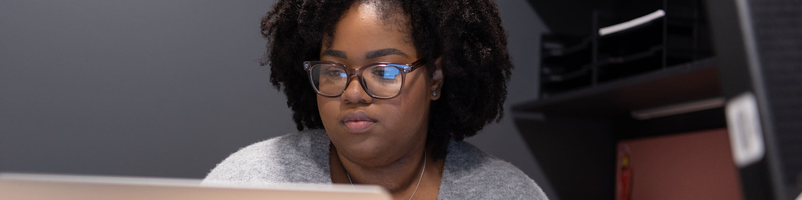 A student worker works at her desk.